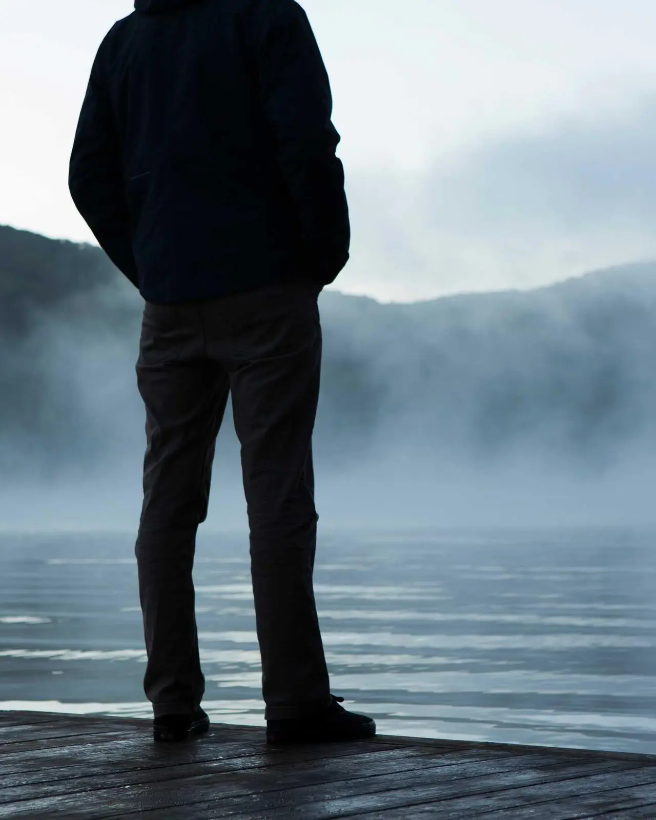 Silhouette face à un lac dans la brume